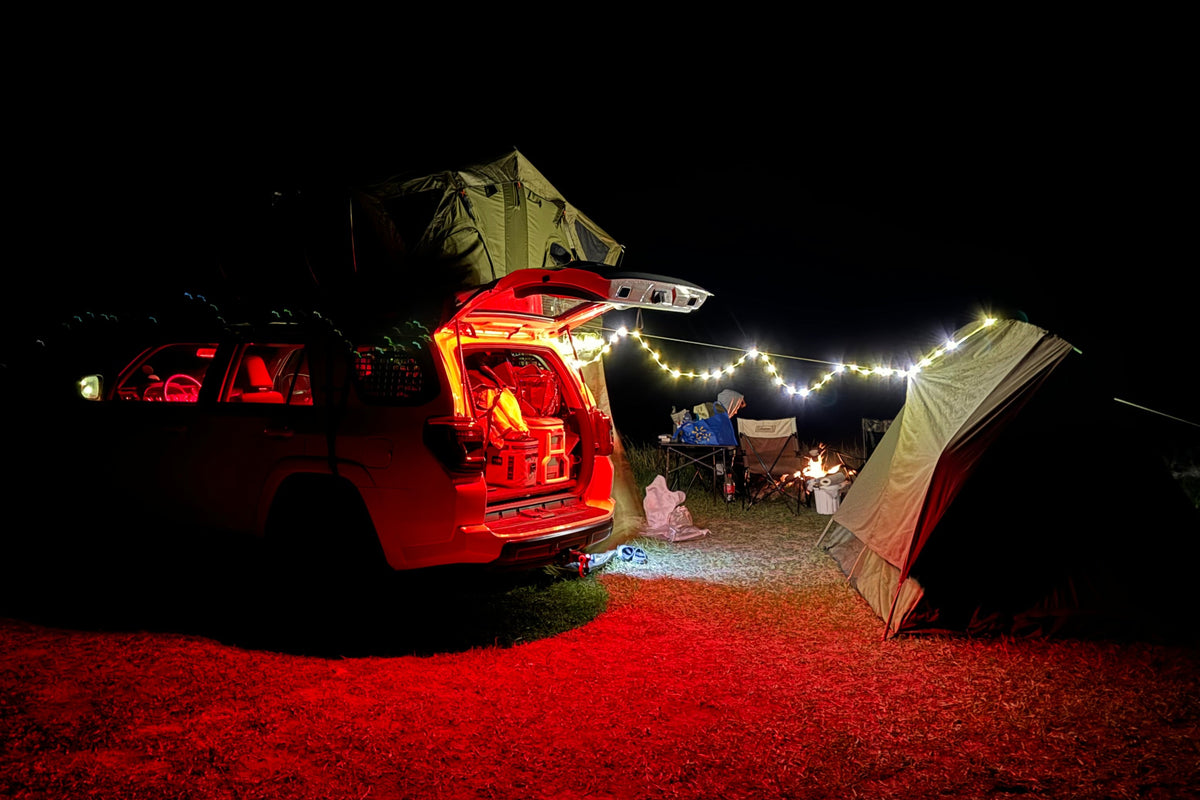 5th Gen Toyota 4Runner with rooftop tent at a night campsite, hatch open under string lights